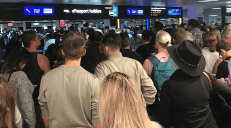 A person holding a passport and a smartphone, looking confused at travel documents