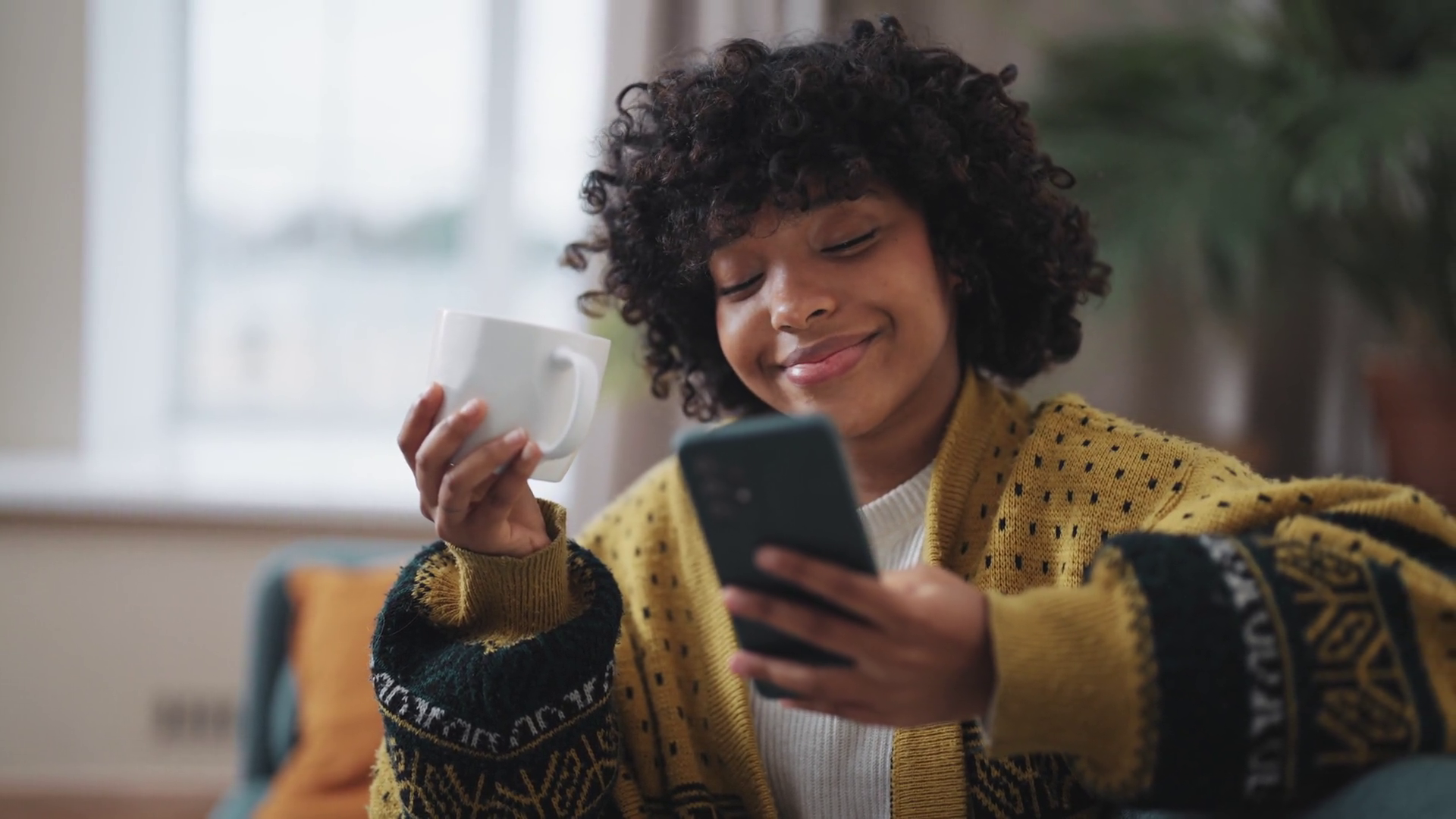 australian woman solving nyt connections on phone with coffee in hand