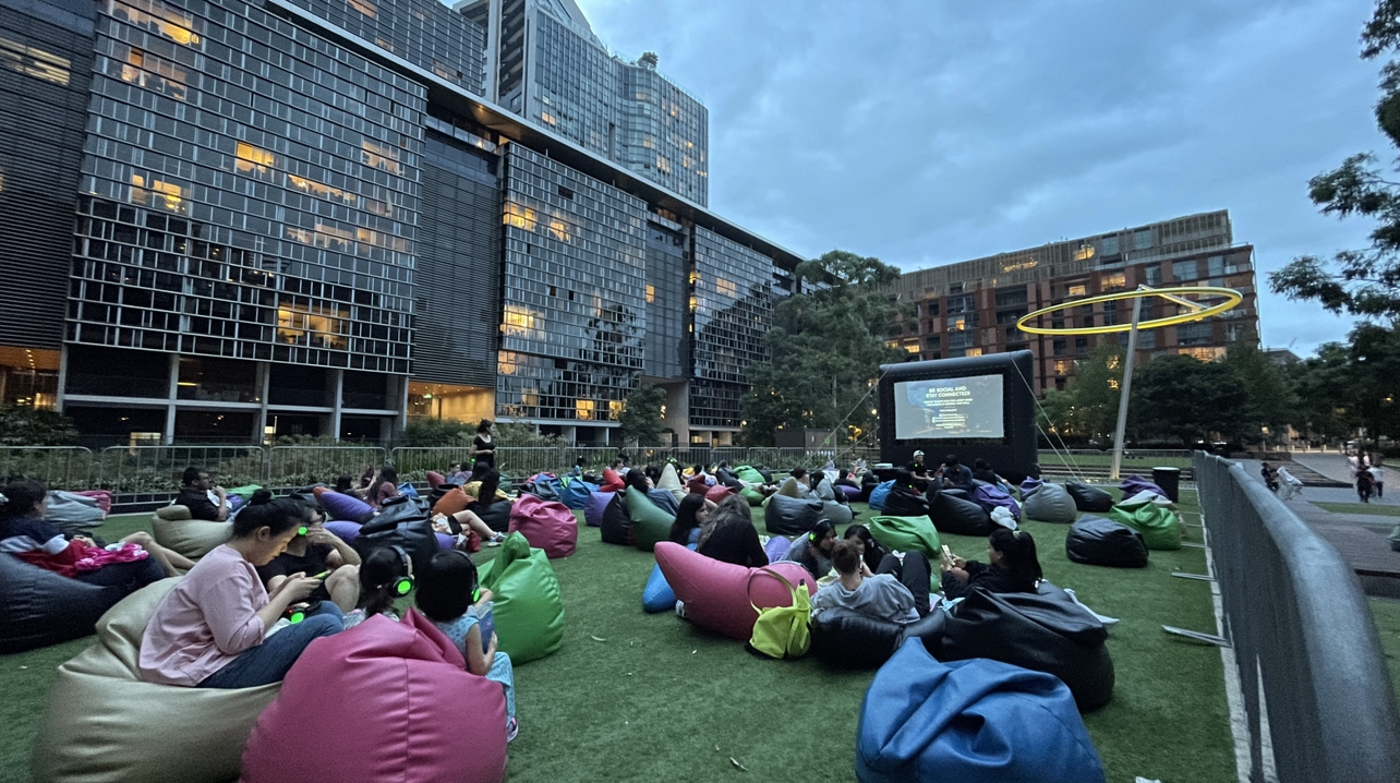 Outdoor Christmas movie screening in Sydney park with string lights and blankets