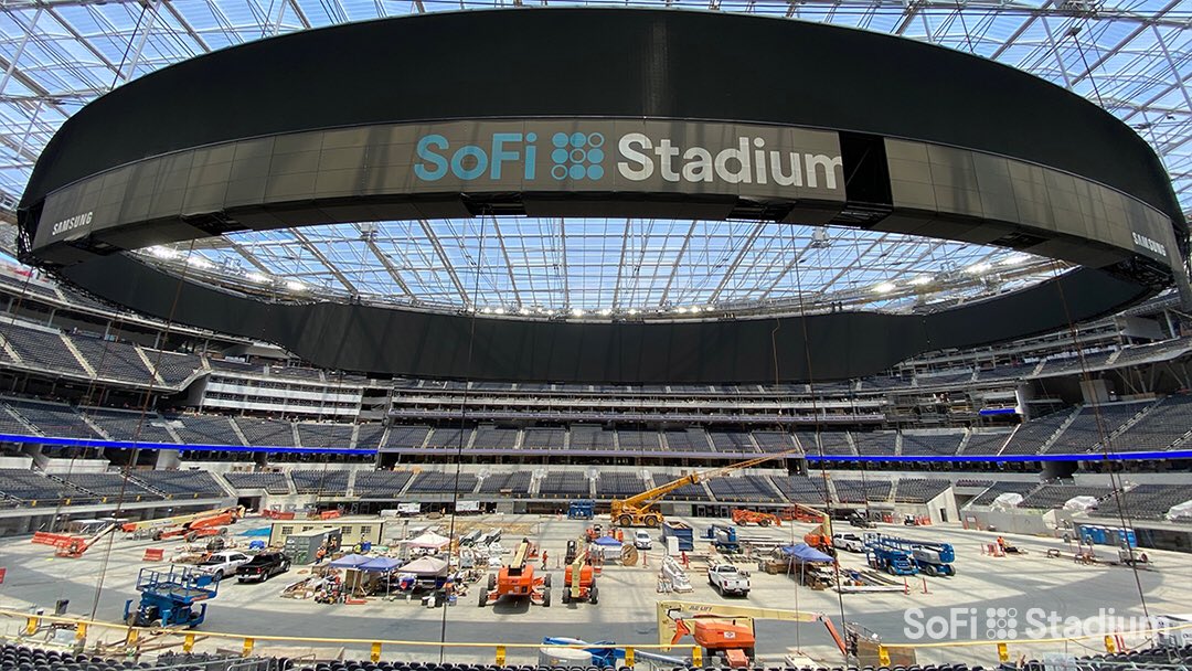 Stade avec écran géant diffusant un match de football