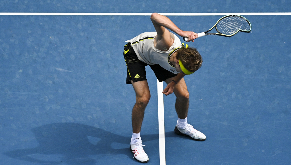 Tennis player smashing racket